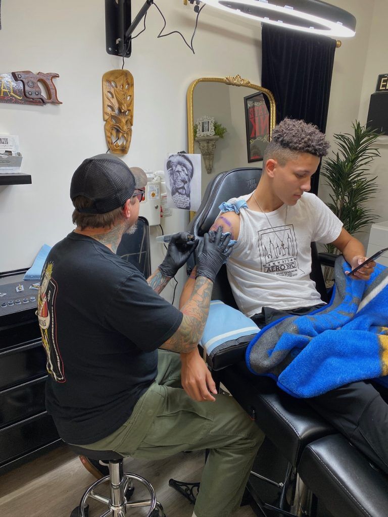 Elvis tattooing a client in his Nashville tattoo shop